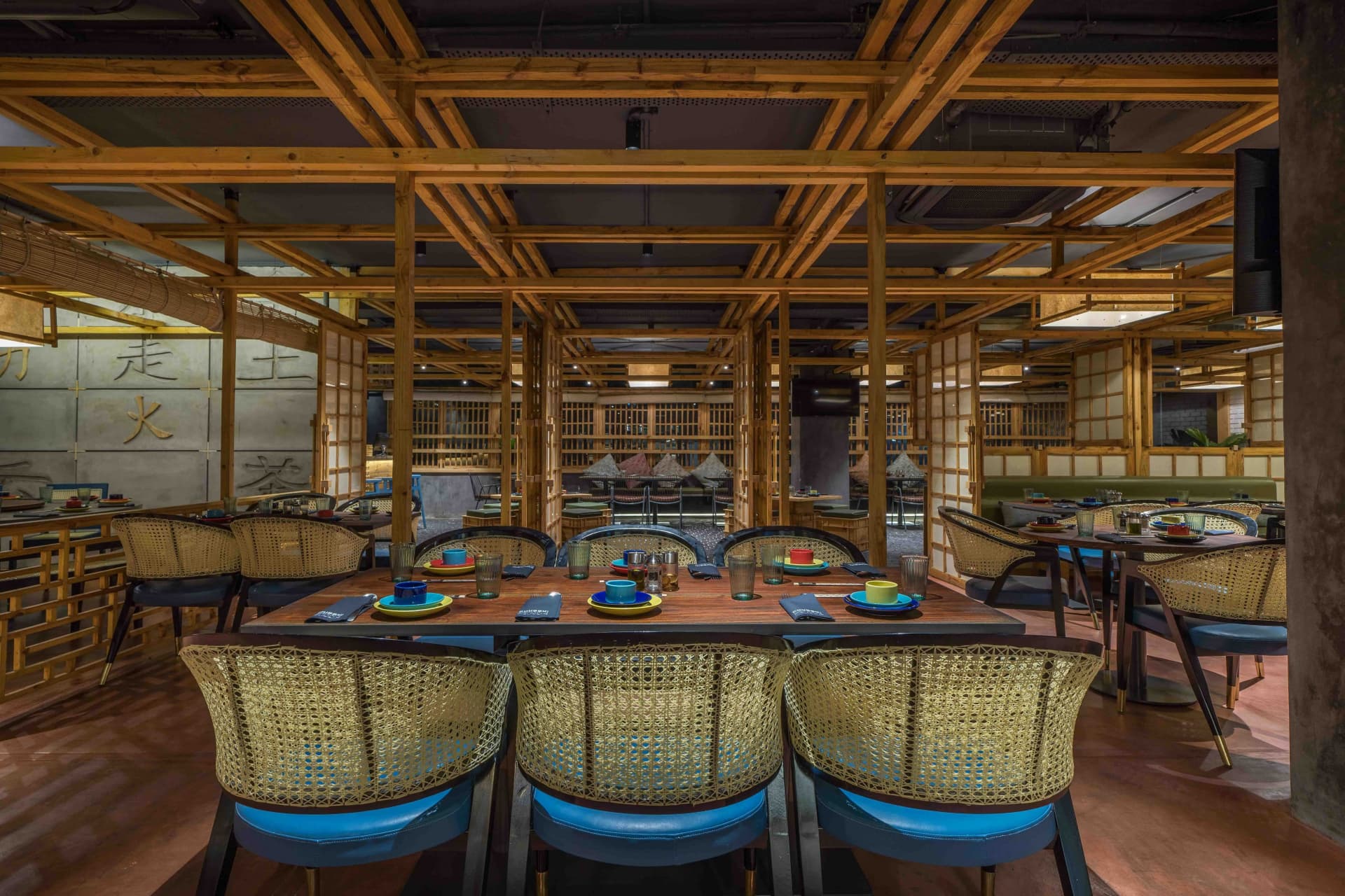 Dining hall with rattan chairs and set tables at Chubby Cho